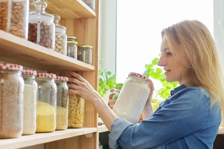 Mulher olha para armário enquanto investiga vestígios de traça de alimentos