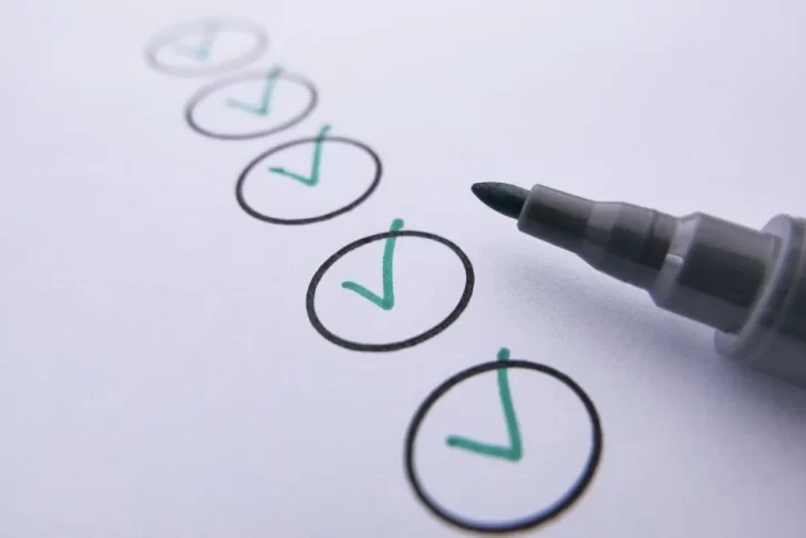 caneta ao lado de folha com marcações de checklist de limpeza