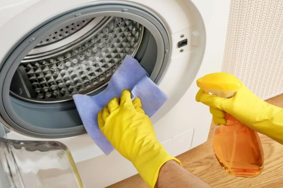 foto de pessoa fazendo limpeza de máquina de lavar